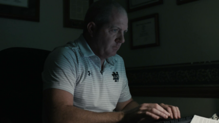 Attorney Paul Farrell Jr. sitting in a dark room and typing on a keyboard.